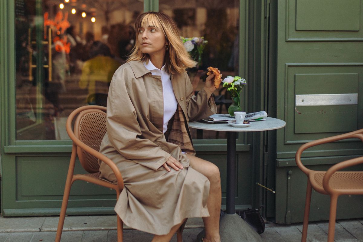 An image of a stylish woman sitting outside cafe. The photo is used for a blog about Valentine's Day. 